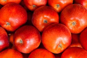 Pommes rouges vibrantes empilées ensemble, mettant en avant leur fraîcheur et leur aspect juteux.