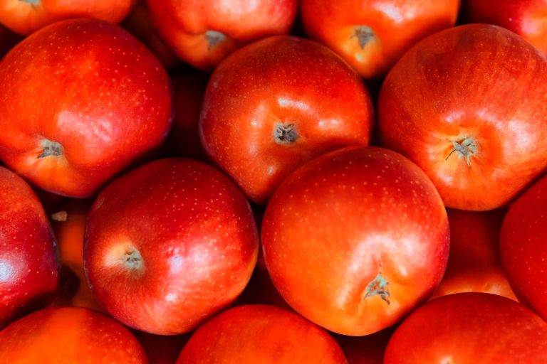 Pommes rouges vibrantes empilées ensemble, mettant en avant leur fraîcheur et leur aspect juteux.